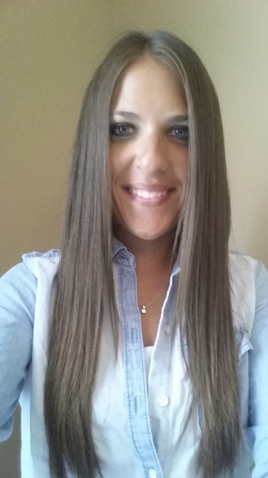 A woman with long brown hair is taking a selfie to show off her Neutrogena Triple Repair results.