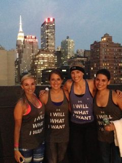 Four women stay motivated while posing for a photo on a rooftop in NYC.