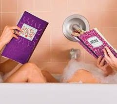 Two sisters sitting in a bathtub reading books.