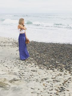 Reality TV star Juelia Kinney posing on the beach in a blue maxi skirt.