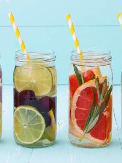 Four jars filled with fruit-infused water.