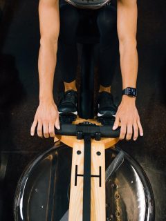 A woman experiencing the benefits of rowing during her gym workout on a rowing machine.