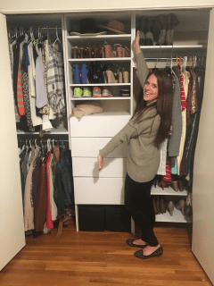 A woman organizing her modular closet full of clothes.