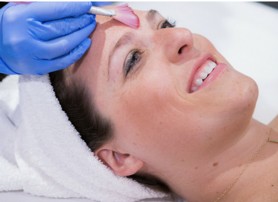 A woman receives a refreshing HydraFacial treatment at a serene spa.