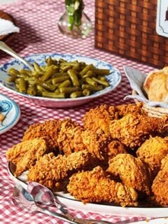 A Cracker Barrel table with fried chicken and other food on it.