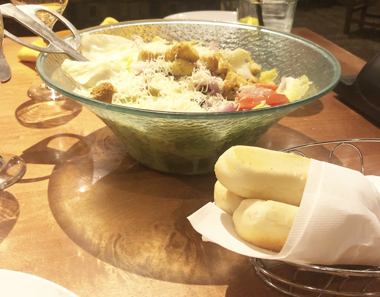 A salad and bread on a table at Olive Garden.