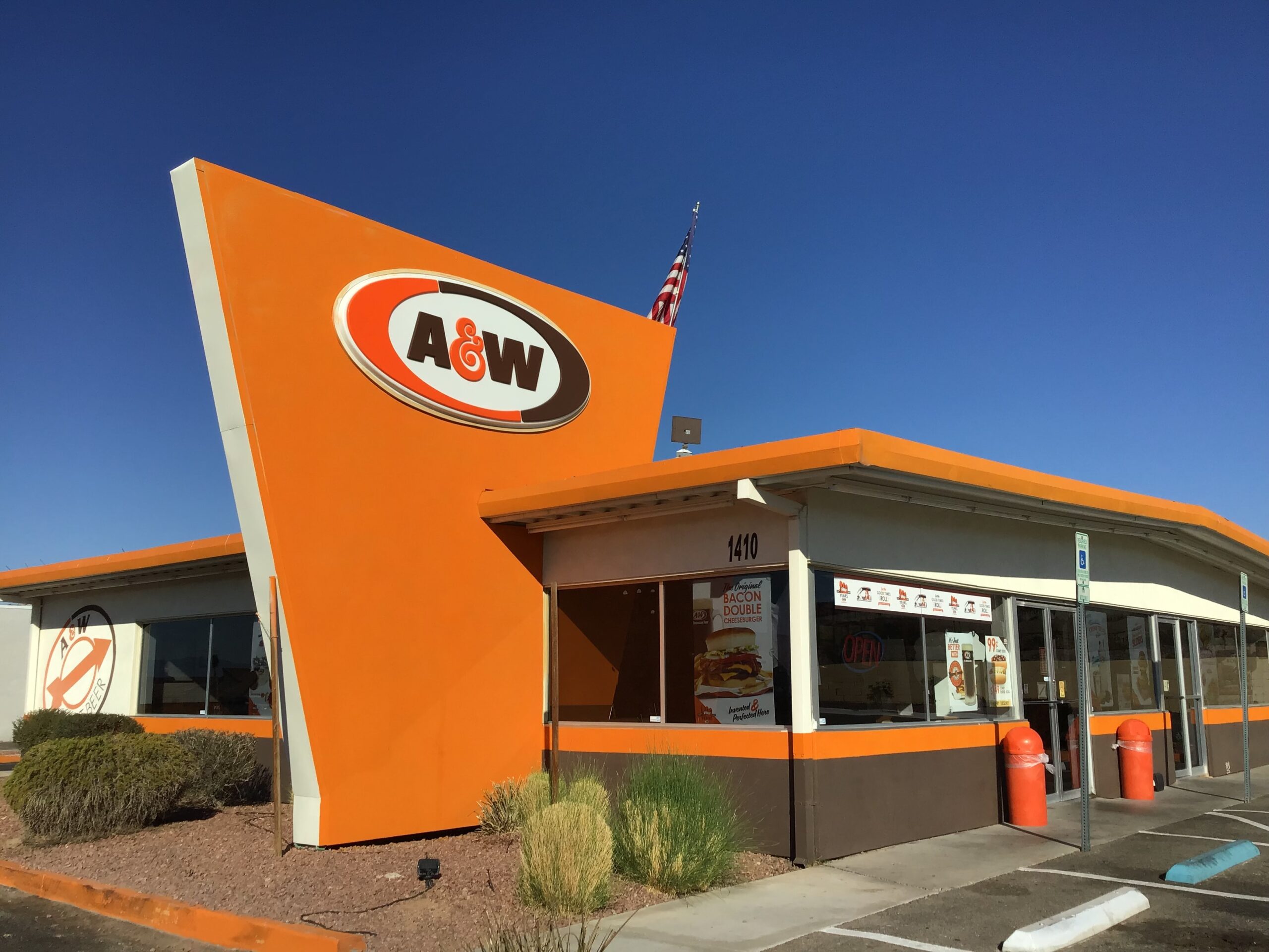 A fast food restaurant with an orange and black sign in the A&W food chain.