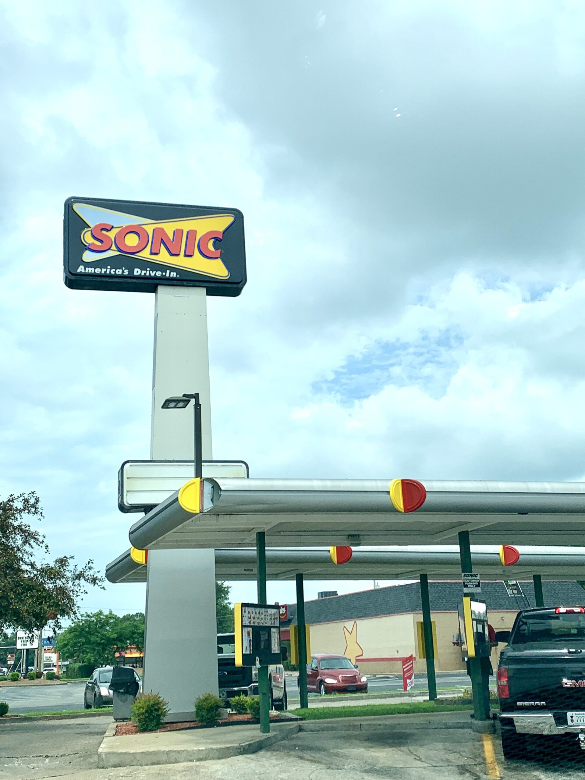A sonic gas station with cars parked in front of it.