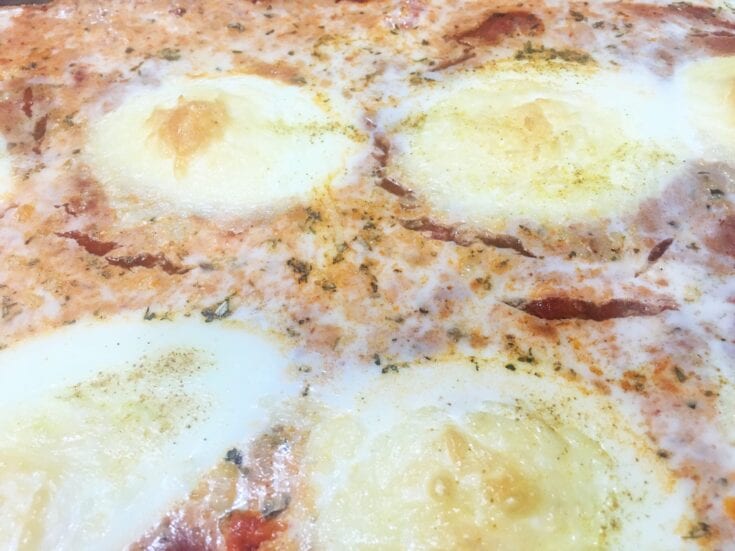 An Italian-style pizza topped with baked eggs.