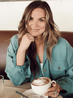 A woman, Hannah Brown, sitting at a table with a cup of coffee.