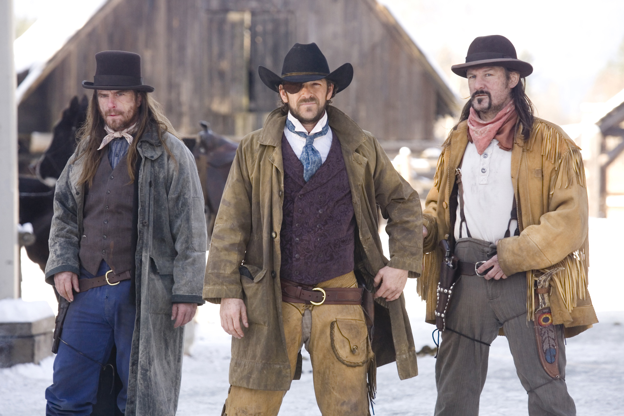 Three men in cowboy hats standing in the snowy wilderness of a western.