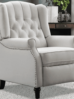 A white recliner chair that helps relieve back pain in a living room.