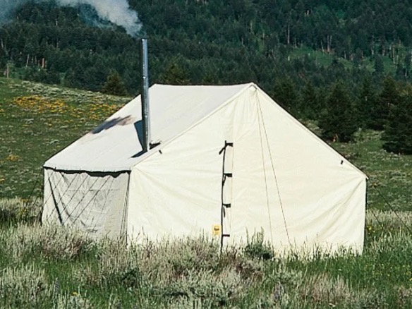 The Wall Tent Shop white canvas tent is pictured. The tent is white and tall, equipped with a buckle and zipper over the entrance. 