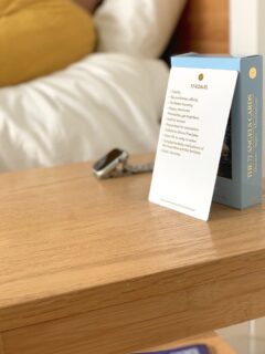 A card sits on a table next to a bed.