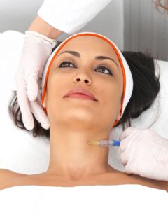 A woman receiving a botox injection on her neck.