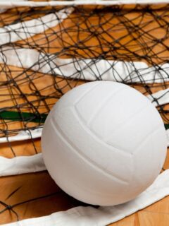 A volleyball ball sitting on top of a net.