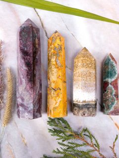 Four different types of quartz crystals on a marble surface, including crystals for pain relief.