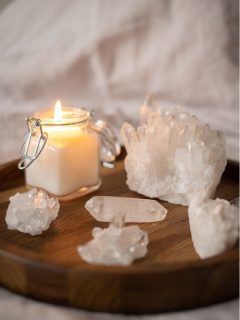 Crystals for peace and calm placed on a wooden tray with a candle.