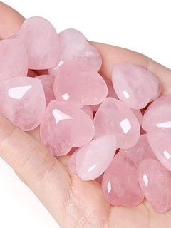 A person holding a bunch of pink quartz stones, powerful crystals for intuition.