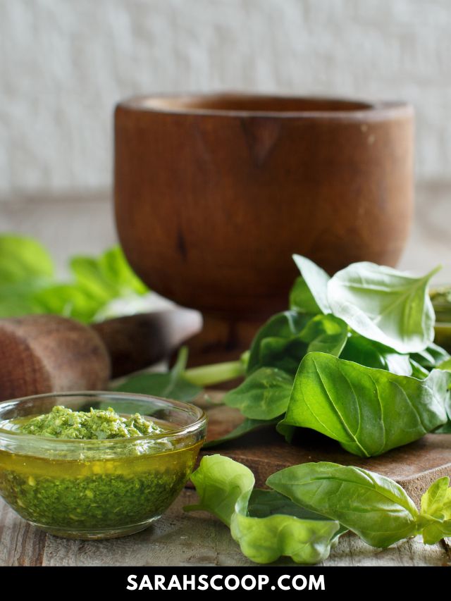 A classic green goddess salad with basil pesto on a wooden table.