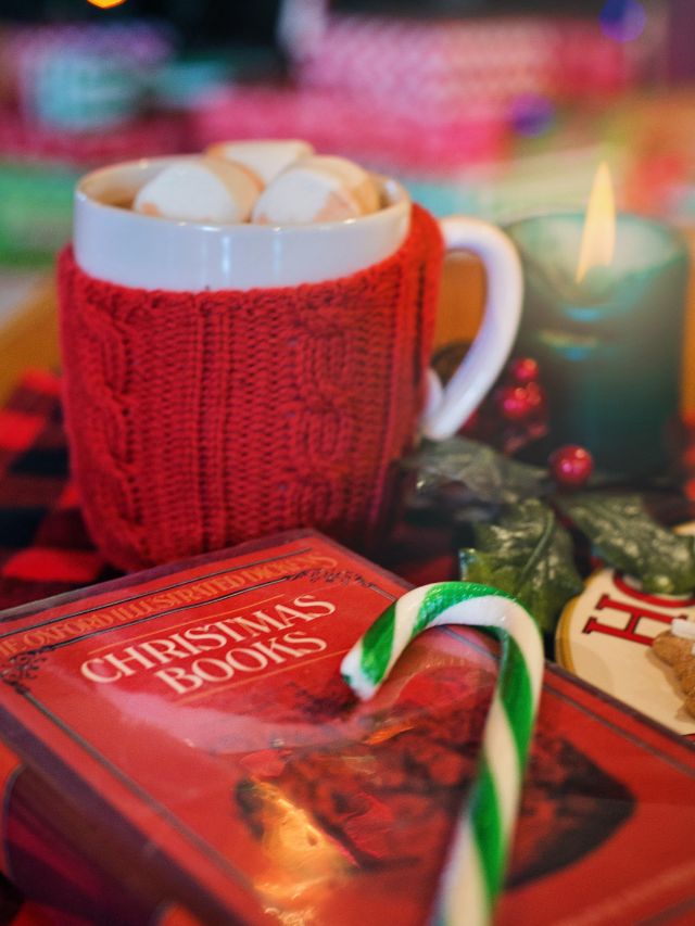 Hot coco mug, Christmas book, and candy cane