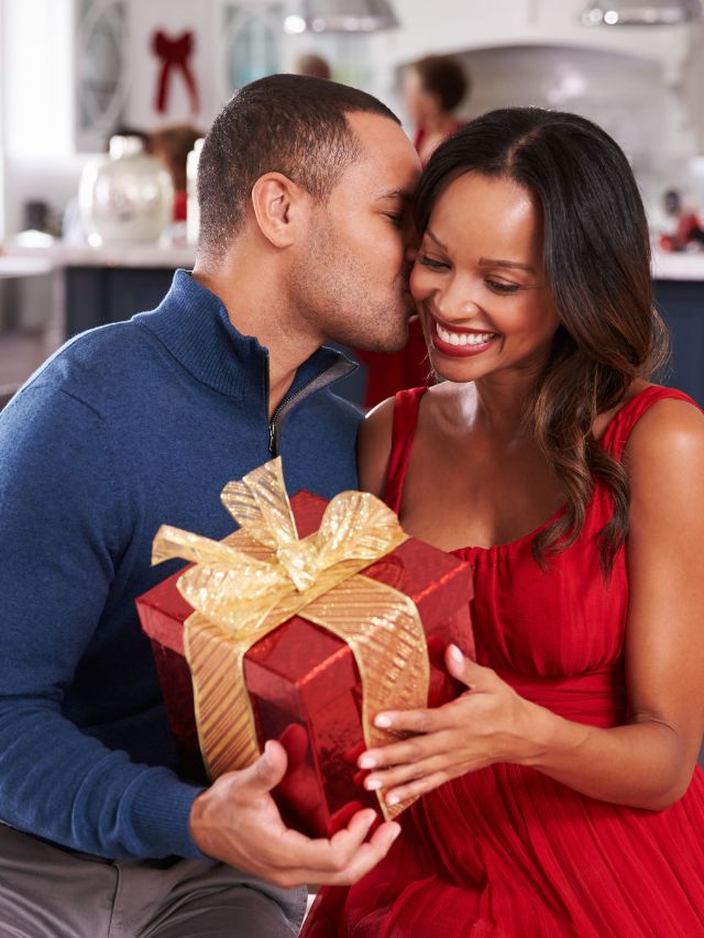 couple kissing and holding presents