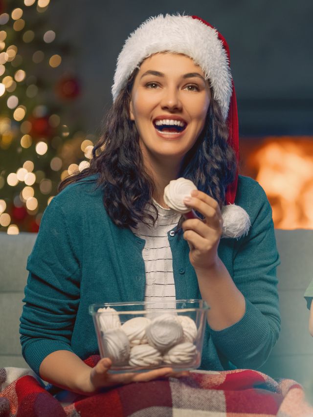 woman wearing a santa hat and eating cookies