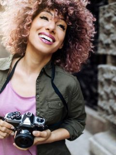 curly hair woman holding camera