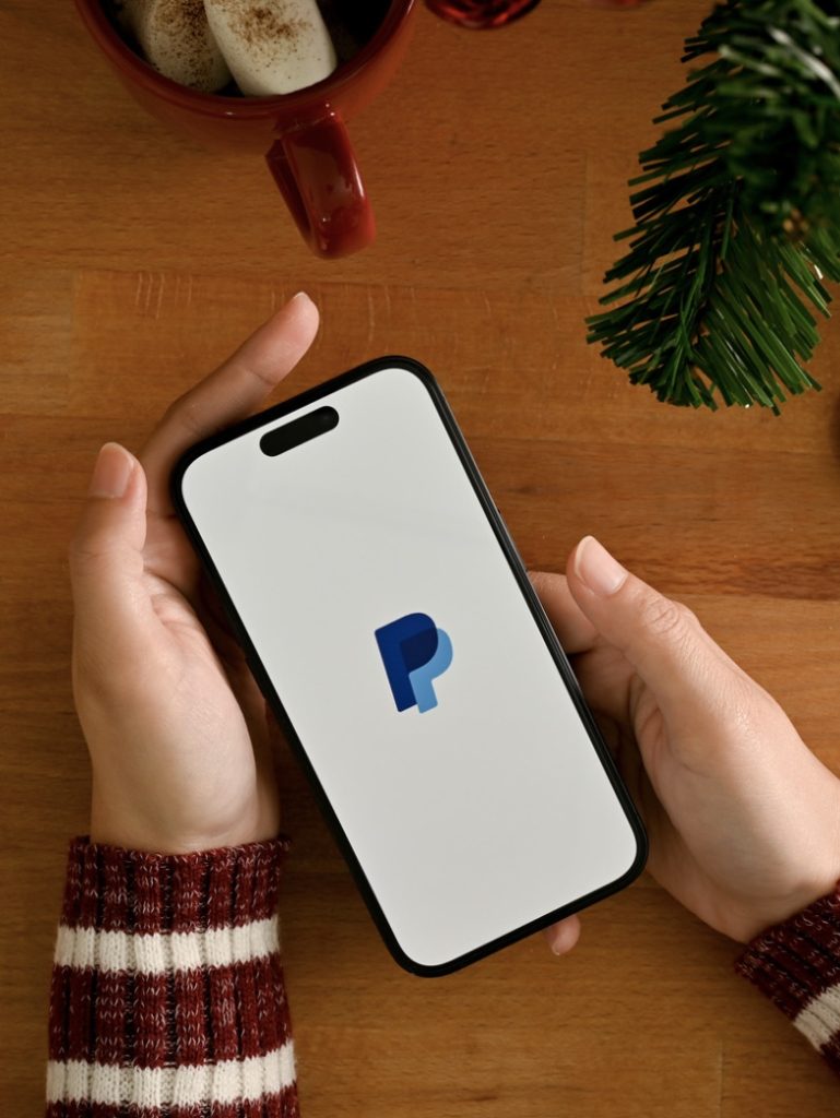 hands holding phone while using paypal