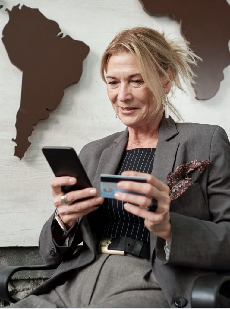 woman in suit holding phone and credit card
