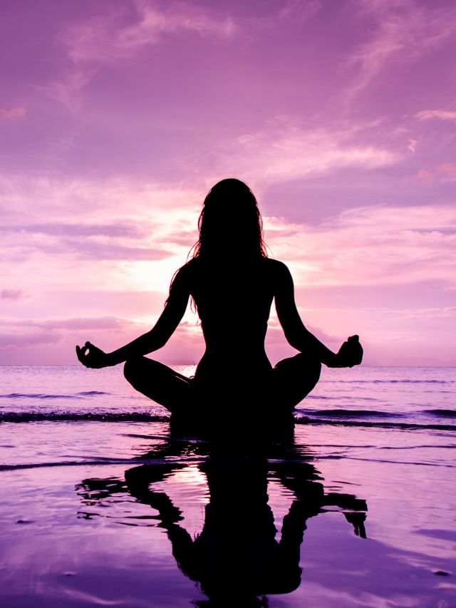 woman in lotus position sitting in sea and meditating