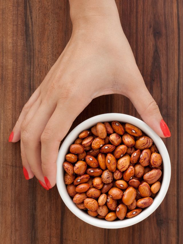 woman hand holding bowl full of pinto beans