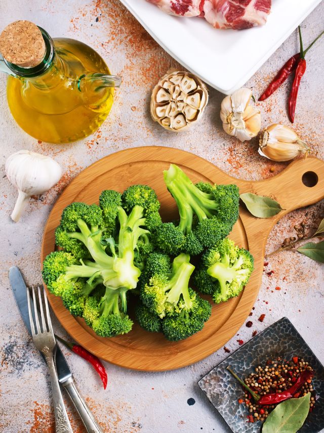raw broccoli on cutting board with spices and herbs