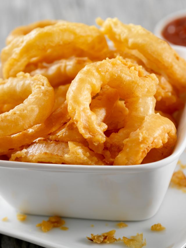 onion rings in bowl with ketchup