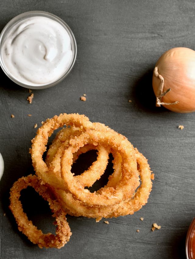 top view of fried onion rings on a dark background