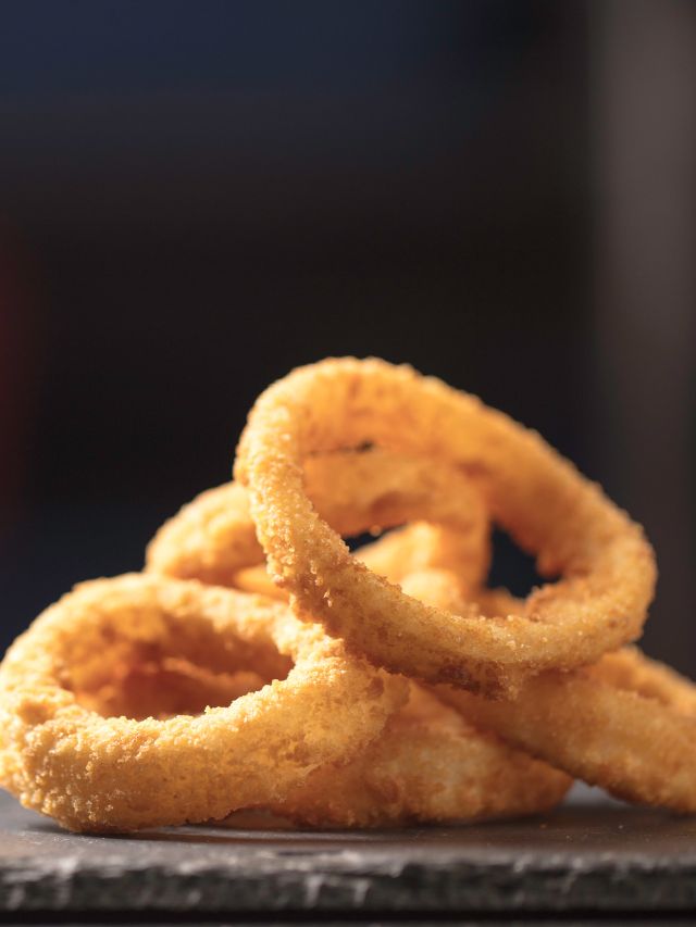 stack of onion rings on a slate serving tray