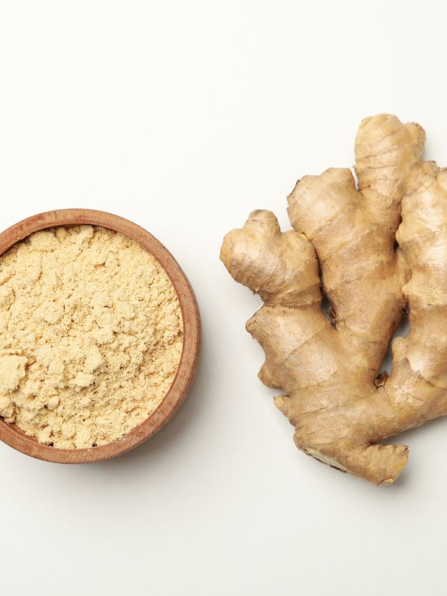 ginger and bowl with ginger powder on white background