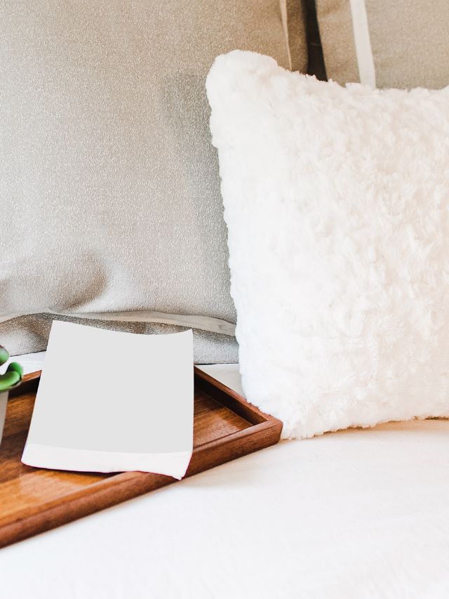 fluffy white pillow with book on bed