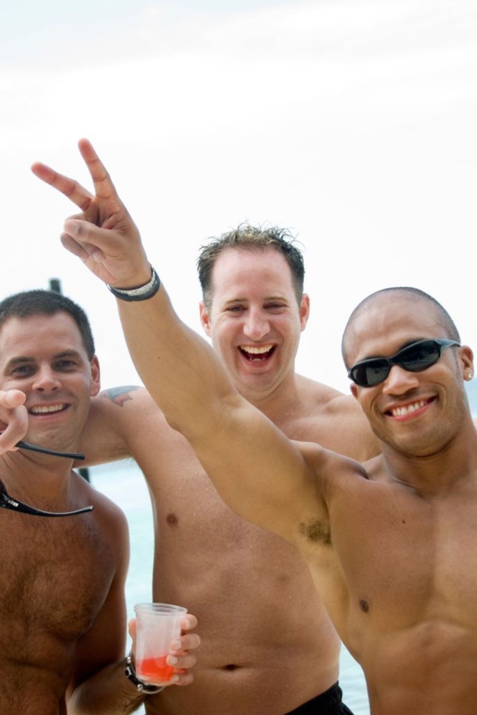 three men celebrating on the beach