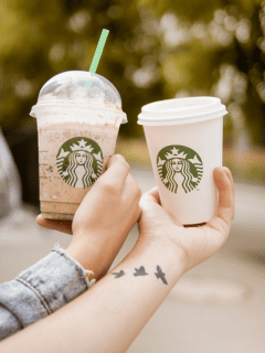 Two people holding Starbucks cups with tiktok starbucks iced coffee and white mocha on them.