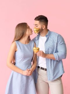 Pink background with a couple kissing on Valentine's day.