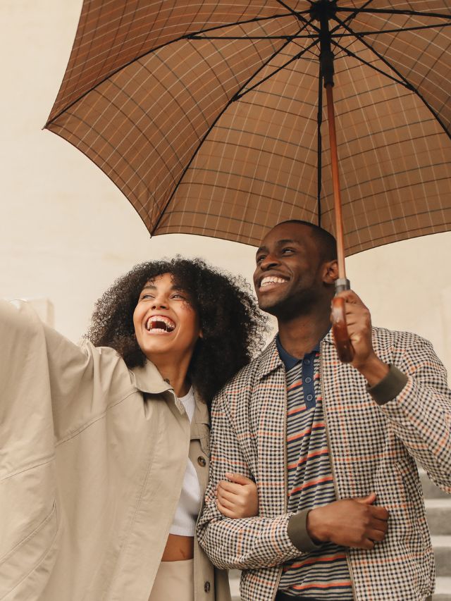 man and woman laughing in the rain