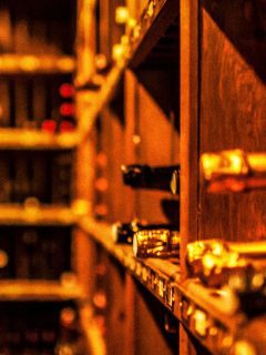 A row of wine bottles in a temperature-controlled wine cellar.