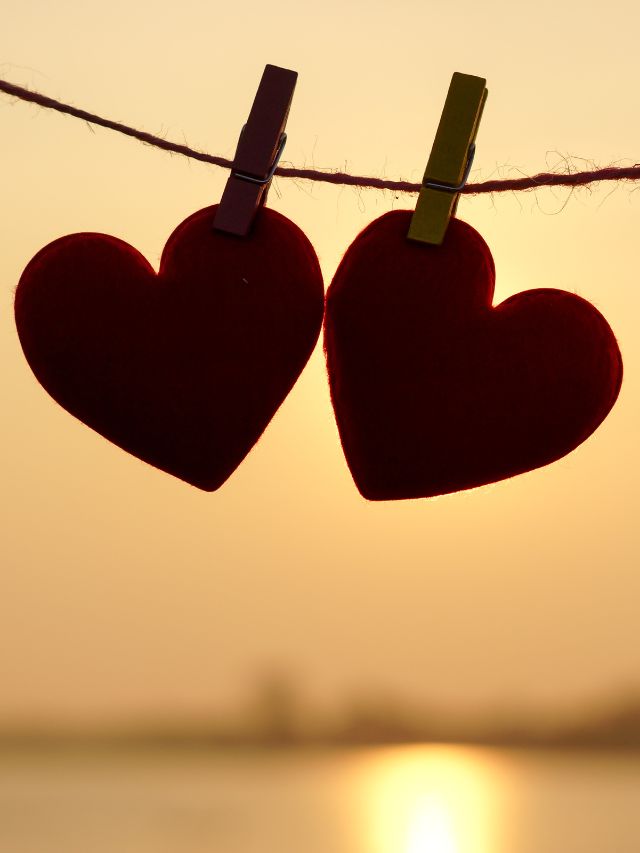 two red hearts hung on a rope together with clips love manifestation affirmations
