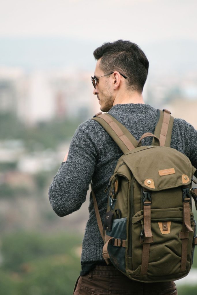man wearing backpack with sweater