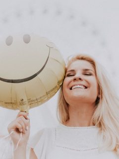 A woman spreading positivity with a smiley face balloon.