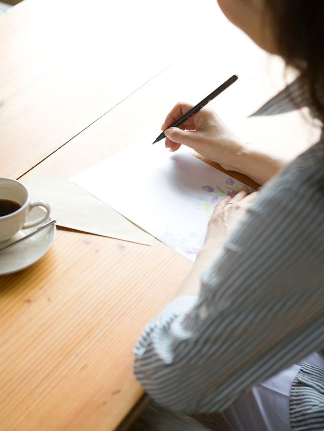 woman writing letter with coffee