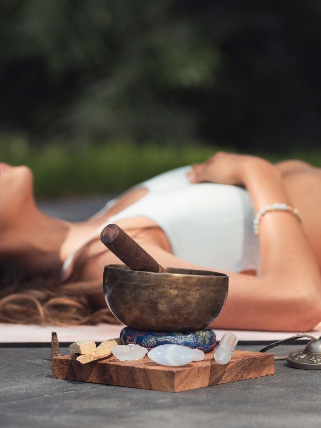 singing bowl with crystals and woman laying down