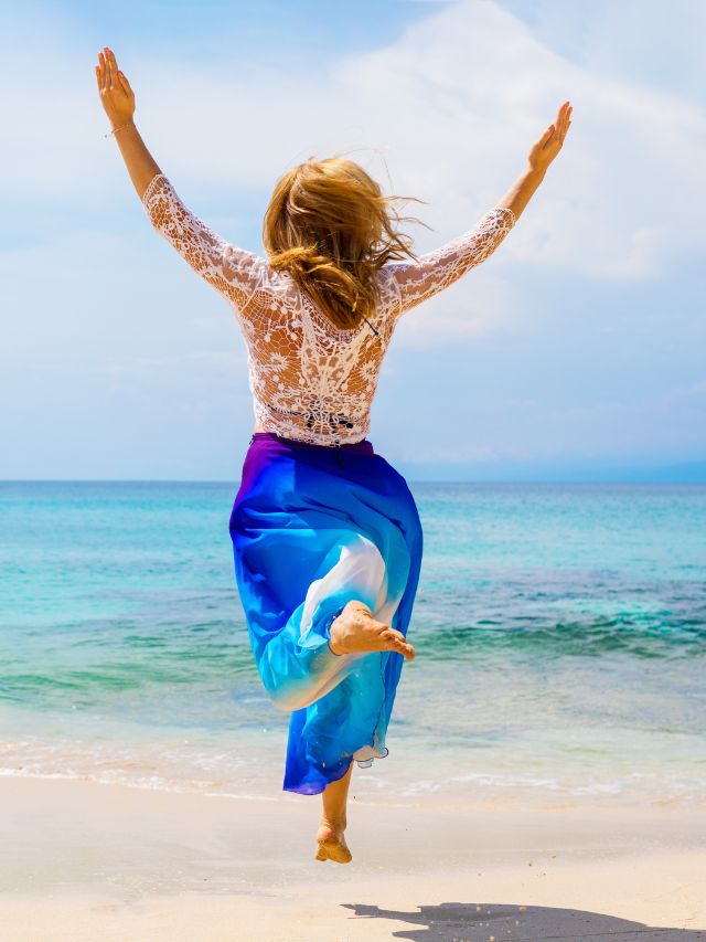 woman having a greta happy life jumping on the beach