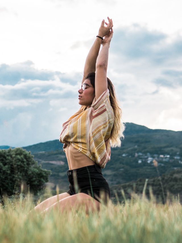 woman doing yoga on mountain
